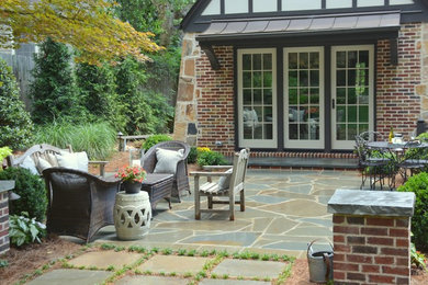 Photo of a mid-sized backyard patio in Atlanta with natural stone pavers.