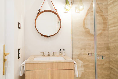 Kleines Klassisches Duschbad mit flächenbündigen Schrankfronten, hellen Holzschränken, beigen Fliesen, weißer Wandfarbe, integriertem Waschbecken, Marmor-Waschbecken/Waschtisch, Falttür-Duschabtrennung und beiger Waschtischplatte in München