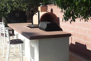 Mid-sized elegant backyard concrete patio kitchen photo in Los Angeles with no cover