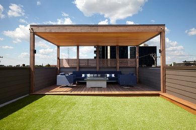 Inspiration for a large contemporary rooftop deck remodel in Chicago with a fire pit and a pergola