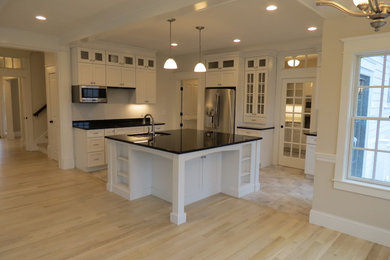 Inspiration for a large timeless u-shaped ceramic tile eat-in kitchen remodel in Boston with an undermount sink, recessed-panel cabinets, white cabinets, granite countertops, stainless steel appliances and an island