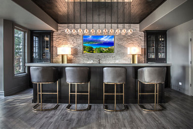 Inspiration for a modern galley seated home bar in Chicago with glass-front cabinets, black cabinets, concrete benchtops, grey splashback, stone tile splashback, dark hardwood floors, grey floor and grey benchtop.