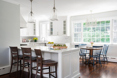 Eat-in kitchen - mid-sized traditional u-shaped medium tone wood floor and brown floor eat-in kitchen idea in Philadelphia with an undermount sink, shaker cabinets, white cabinets, quartz countertops, gray backsplash, marble backsplash, stainless steel appliances, a peninsula and white countertops