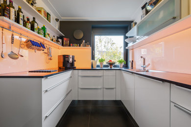 Geschlossene, Kleine Moderne Küche in U-Form mit Glasrückwand