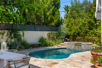 Hot tub - mediterranean stone and kidney-shaped hot tub idea in Los Angeles
