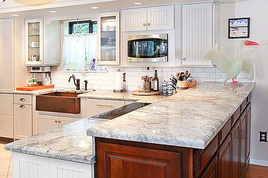 Mid-sized transitional u-shaped ceramic tile kitchen pantry photo in Miami with a farmhouse sink, white cabinets, quartzite countertops, white backsplash, ceramic backsplash, stainless steel appliances, a peninsula and louvered cabinets