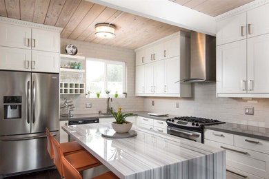 Mid-sized trendy l-shaped dark wood floor and brown floor eat-in kitchen photo in San Diego with a single-bowl sink, shaker cabinets, white cabinets, marble countertops, gray backsplash, ceramic backsplash, stainless steel appliances, an island and gray countertops