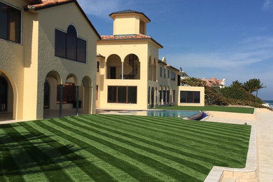 Design ideas for a large mediterranean partial sun backyard concrete paver landscaping in Miami.