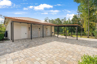 Example of a large transitional detached three-car garage workshop design in Miami