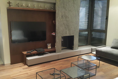 Foto de sala de estar abierta moderna de tamaño medio con paredes blancas, suelo de madera en tonos medios, todas las chimeneas, marco de chimenea de piedra, pared multimedia y suelo marrón