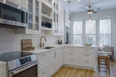 Inspiration for a mid-sized contemporary single-wall light wood floor enclosed kitchen remodel in Other with an undermount sink, glass-front cabinets, white cabinets, quartz countertops, multicolored backsplash, porcelain backsplash, stainless steel appliances, an island and white countertops