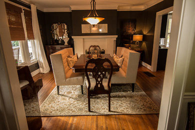 This is an example of a large transitional separate dining room in Charlotte with brown walls, medium hardwood floors, a standard fireplace and a plaster fireplace surround.