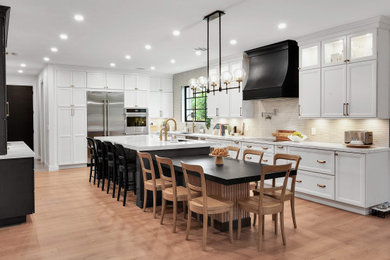 Inspiration for a large transitional u-shaped open concept kitchen remodel in Miami with recessed-panel cabinets, white cabinets, quartz countertops and two islands