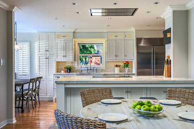 Enclosed kitchen - mid-sized transitional single-wall medium tone wood floor enclosed kitchen idea in Phoenix with an undermount sink, shaker cabinets, white cabinets, marble countertops, gray backsplash, subway tile backsplash, stainless steel appliances and an island