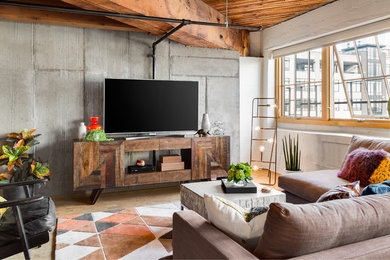 Inspiration for a mid-sized industrial open concept family room in Portland with white walls, medium hardwood floors, no fireplace, a freestanding tv and brown floor.