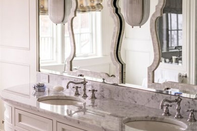 Transitional bathroom photo in Boston with recessed-panel cabinets, white cabinets, white walls, a drop-in sink and marble countertops
