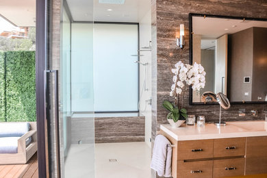 Inspiration for a mid-sized contemporary master beige floor bathroom remodel in Los Angeles with flat-panel cabinets, medium tone wood cabinets, brown walls, an integrated sink, marble countertops and beige countertops