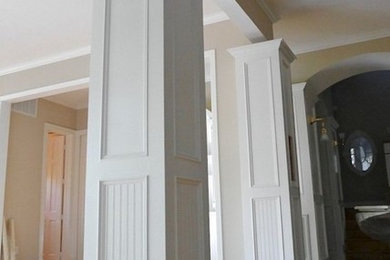 Hallway - mid-sized medium tone wood floor hallway idea in Houston with beige walls