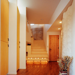 他の地域の地中海スタイルのおしゃれな玄関 (白い壁、テラコッタタイルの床、オレンジの床) の写真