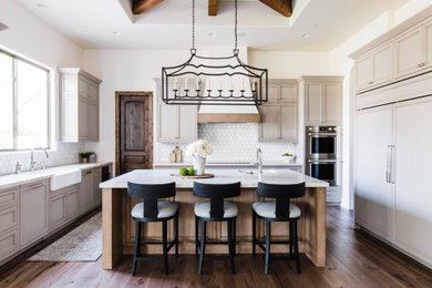 Large tuscan u-shaped medium tone wood floor and brown floor open concept kitchen photo in Phoenix with recessed-panel cabinets, quartzite countertops, an island, an undermount sink, gray cabinets, white backsplash, paneled appliances and white countertops