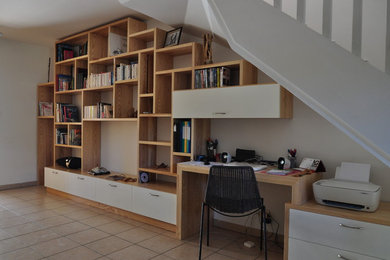 Foto de despacho contemporáneo grande sin chimenea con biblioteca, paredes blancas, suelo de baldosas de cerámica, escritorio empotrado y suelo beige