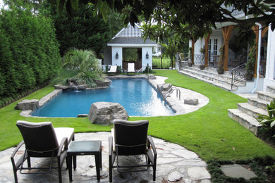 Diseño de piscina en patio trasero con paisajismo de piscina y adoquines de piedra natural