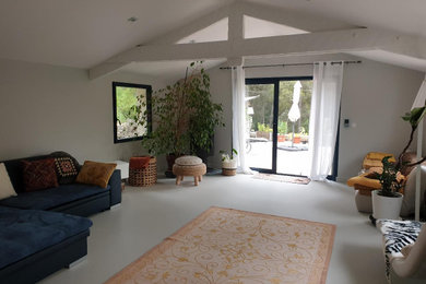 Imagen de salón tipo loft y gris y blanco mediterráneo grande con paredes grises, suelo de cemento, estufa de leña, suelo gris y vigas vistas