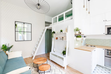 Cette image montre un petit salon nordique ouvert avec un mur blanc, parquet clair, un téléviseur fixé au mur, un sol beige et du papier peint.