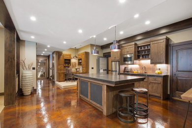 Example of a large eclectic galley kitchen design in Detroit with shaker cabinets, brown cabinets, granite countertops, metallic backsplash, stainless steel appliances, an island and gray countertops
