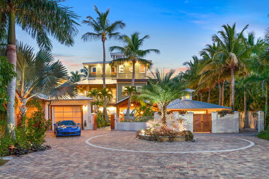 Example of an island style green three-story house exterior design in Other with a hip roof and a metal roof