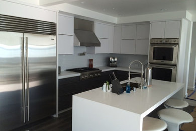 Inspiration for a mid-sized contemporary u-shaped eat-in kitchen remodel in San Francisco with a double-bowl sink, white cabinets, solid surface countertops, blue backsplash, subway tile backsplash, stainless steel appliances and an island