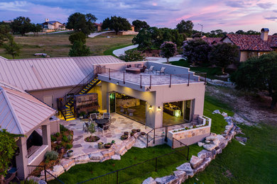 Large mediterranean beige one-story stucco exterior home idea in Austin with a metal roof