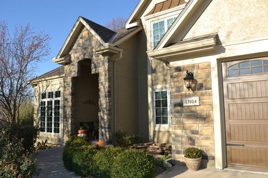 This is an example of a traditional beige exterior in Kansas City with stone veneer.