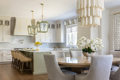 Eat-in kitchen - large transitional l-shaped medium tone wood floor and beige floor eat-in kitchen idea with a farmhouse sink, shaker cabinets, beige cabinets, quartz countertops, white backsplash, subway tile backsplash, paneled appliances, an island and white countertops