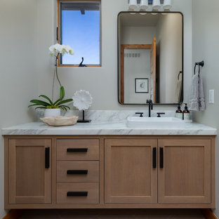 Example of a transitional gray floor powder room design in Denver with shaker cabinets, light wood cabinets, gray walls, a vessel sink, marble countertops and white countertops