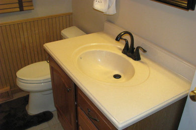 Example of a mid-sized classic 3/4 beige tile and porcelain tile ceramic tile alcove shower design in Wichita with raised-panel cabinets, medium tone wood cabinets, a two-piece toilet, beige walls, an integrated sink and marble countertops