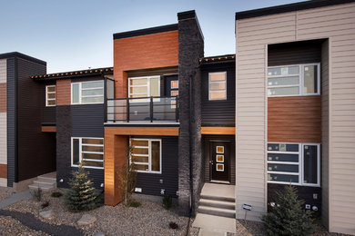 This is an example of a mid-sized contemporary two-storey exterior in Calgary with mixed siding.