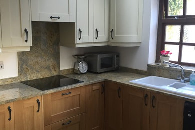 This is an example of a mid-sized traditional u-shaped separate kitchen in Other with a drop-in sink, shaker cabinets, light wood cabinets, granite benchtops, multi-coloured splashback, stone slab splashback, stainless steel appliances, ceramic floors and no island.
