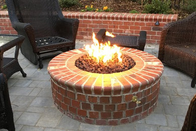 Inspiration for a mid-sized timeless backyard brick patio remodel in Raleigh with a fire pit and no cover