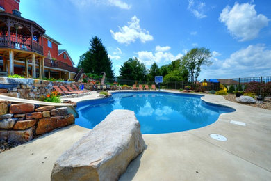 Example of a large classic backyard concrete and kidney-shaped lap water slide design in Philadelphia