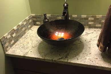 Example of a small transitional multicolored tile and mosaic tile porcelain tile and brown floor powder room design in Chicago with raised-panel cabinets, dark wood cabinets, green walls, a vessel sink and granite countertops