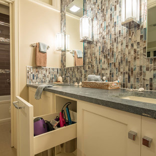 Esempio di una stanza da bagno minimalista di medie dimensioni con lavabo sottopiano, ante in stile shaker, ante bianche, top in saponaria, vasca ad alcova, vasca/doccia, piastrelle multicolore, piastrelle a mosaico, pareti beige e pavimento in gres porcellanato