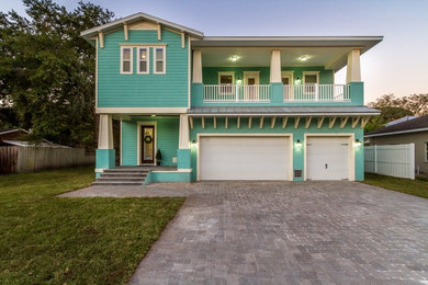 Photo of a large beach style two-storey blue exterior in Tampa with mixed siding and a flat roof.