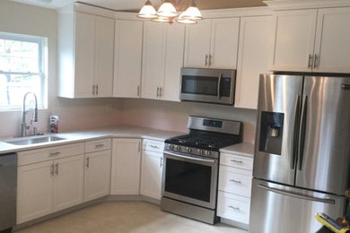 Immagine di una cucina design di medie dimensioni con lavello a vasca singola, ante in stile shaker, ante bianche, top in granito, elettrodomestici in acciaio inossidabile e top bianco
