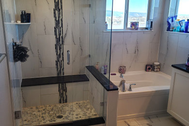 Inspiration for a mid-sized modern master white tile and porcelain tile porcelain tile, white floor and double-sink bathroom remodel in Denver with flat-panel cabinets, white cabinets, a one-piece toilet, gray walls, an undermount sink, granite countertops, a hinged shower door, black countertops and a built-in vanity