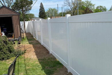 Photo of a large traditional backyard vinyl fence landscaping in Detroit.