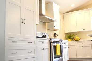 Example of a mid-sized trendy l-shaped dark wood floor open concept kitchen design in St Louis with shaker cabinets, white cabinets, marble countertops, stainless steel appliances and an island