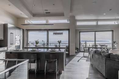 Trendy dark wood floor and brown floor kitchen photo in Vancouver with a double-bowl sink, flat-panel cabinets, dark wood cabinets, granite countertops, paneled appliances and two islands