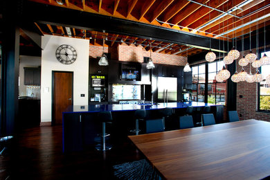 Eat-in kitchen - industrial eat-in kitchen idea in St Louis with an undermount sink, shaker cabinets, dark wood cabinets, solid surface countertops, metallic backsplash, metal backsplash and stainless steel appliances