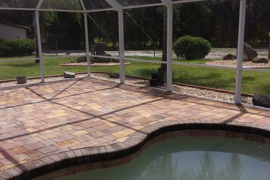 Medium sized indoor custom shaped swimming pool in Orlando with a pool house and natural stone paving.